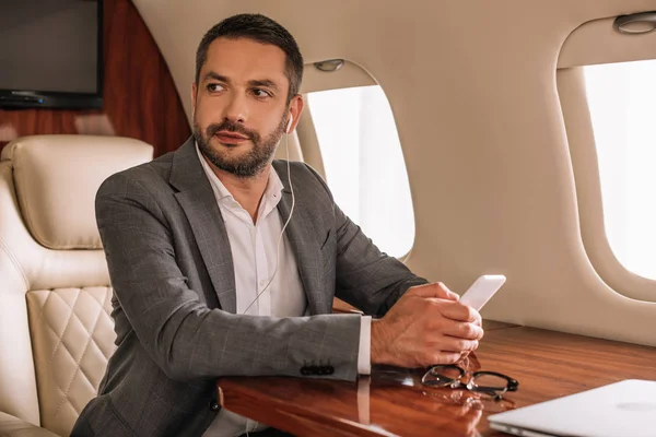 Selective Focus Handsome Businessman Earphones Using Smartphone Private Jet — Stock Photo, Image