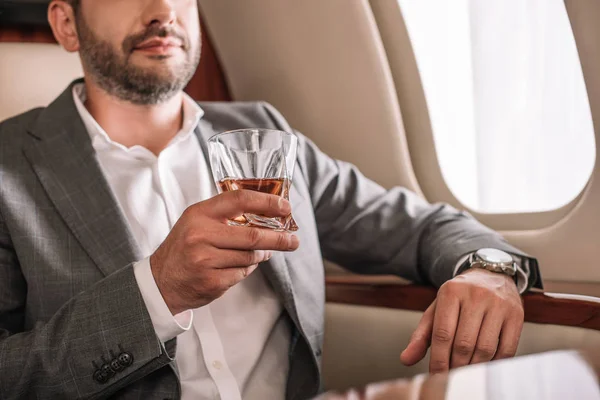 Cropped View Bearded Man Holding Glass Whiskey Private Jet — Stock Photo, Image