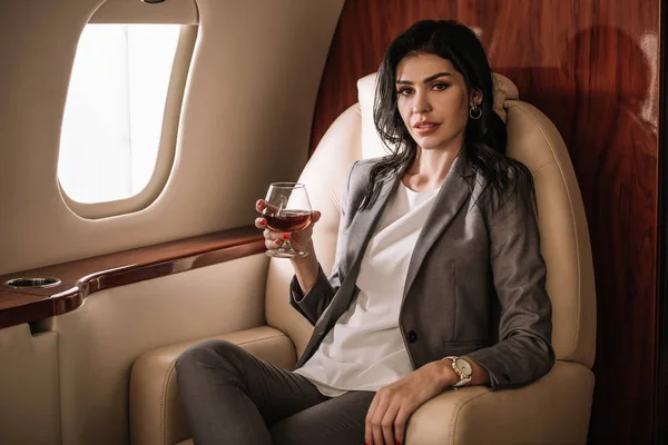Affärskvinna Håller Glas Med Konjak Privat Jet — Stockfoto