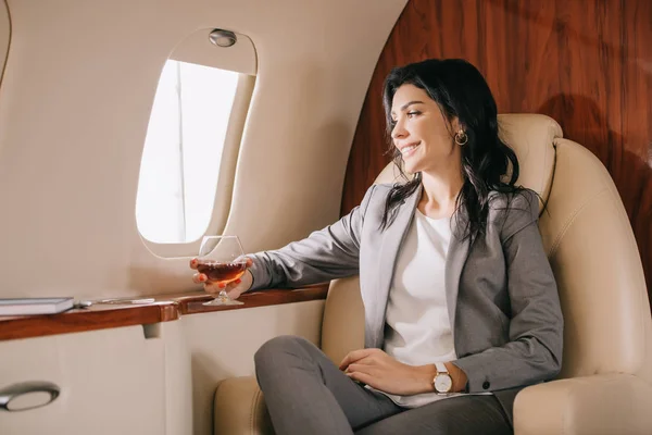 Cheerful Businesswoman Formal Wear Holding Glass Cognac Private Jet — ストック写真