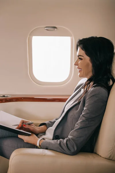 Seitenansicht Einer Fröhlichen Geschäftsfrau Mit Stift Und Notizbuch Flugzeug — Stockfoto