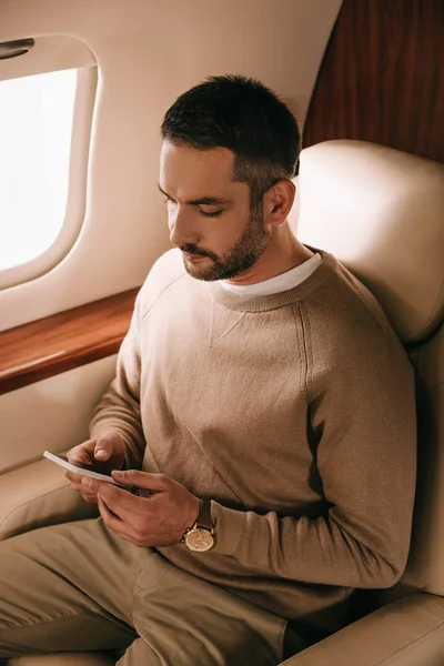 Stilig Skäggig Man Håller Smartphone Privat Jet — Stockfoto