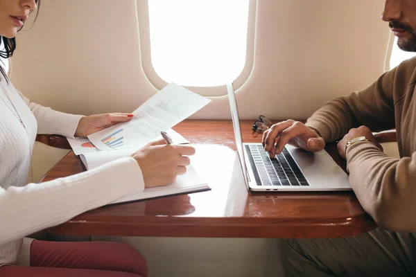 Vista Ritagliata Uomo Utilizzando Laptop Vicino Scrittura Donna Mentre Tenendo — Foto Stock