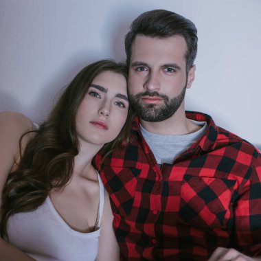 ciddi, ilgili genç bir çift evde televizyon izliyor.