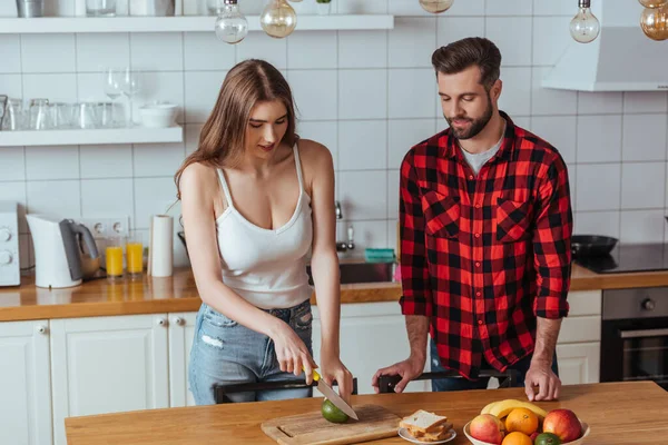 Beautiful Young Woman Cutting Fresh Avocado Handsome Boyfriend — Stock Photo, Image