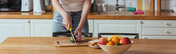 Vista Recortada Niña Cortando Aguacate Cerca Tazón Con Frutas Frescas — Foto de Stock