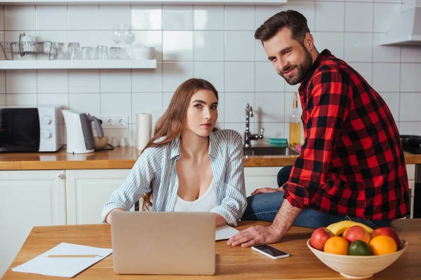 Sorrindo Homem Olhando Para Câmera Enquanto Sentado Mesa Perto Namorada — Fotografia de Stock