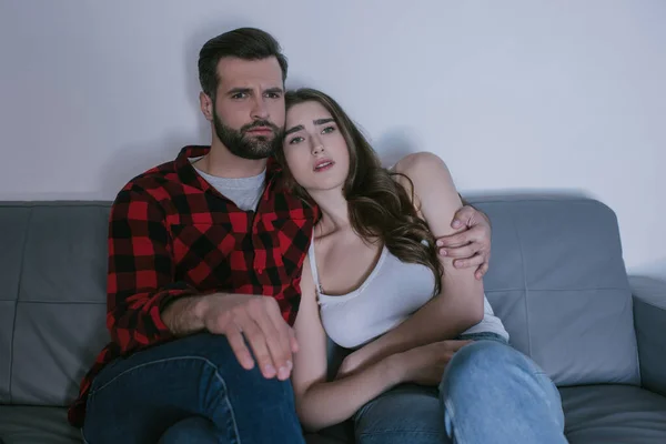 Seria Pareja Preocupada Abrazándose Mientras Televisión Sofá Casa —  Fotos de Stock