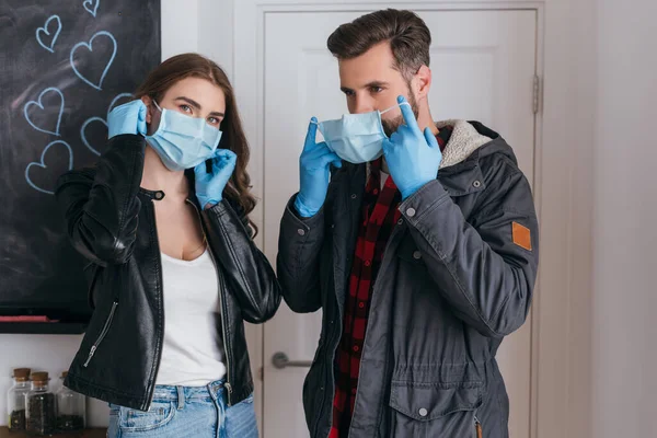 Junges Paar Latexhandschuhen Setzt Schutzmasken Auf Bevor Das Haus Verlässt — Stockfoto