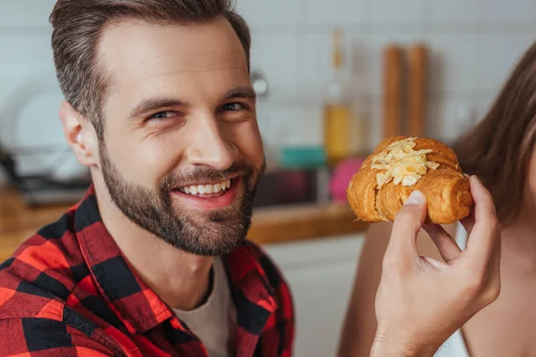 Recortado Vista Chica Cerca Feliz Hombre Sosteniendo Croissant Mirando Cámara — Foto de Stock