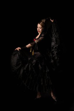 Siyah renkte dans ederken elbiseye dokunan çekici dansçı. 