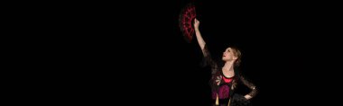 panoramic crop of beautiful dancer looking at fan while dancing flamenco isolated on black  clipart