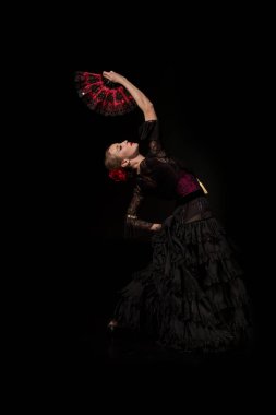 Genç flamenko dansçısı, el ele tutuşup yelpaze ve dans ediyor. 
