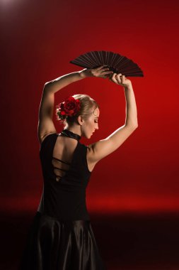 Genç flamenko dansçısı, elinde yelpaze, başının üstünde kırmızı. 