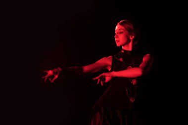 red lighting on beautiful woman dancing flamenco isolated on black   clipart