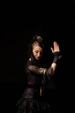 Güzel genç bir dansçı, dua eden elleri siyah renkte flamenko dansı yapıyor. 