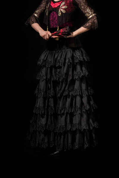 cropped view of flamenco dancer holding fan isolated on black 