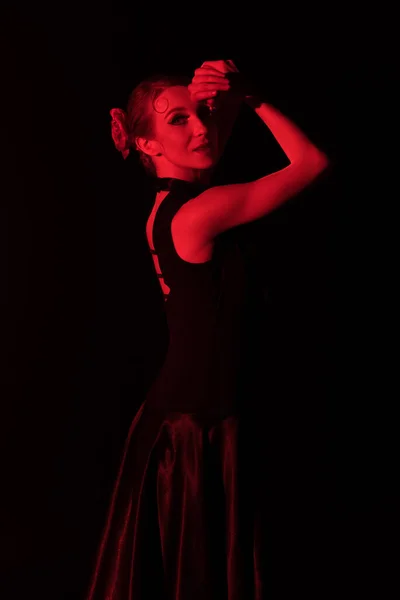 red lighting on attractive flamenco dancer in dress isolated on black