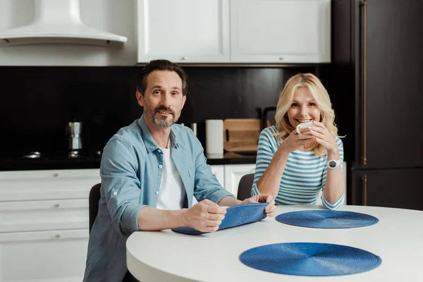 Mujer Sonriente Con Taza Café Mirando Cámara Cerca Del Marido — Foto de Stock