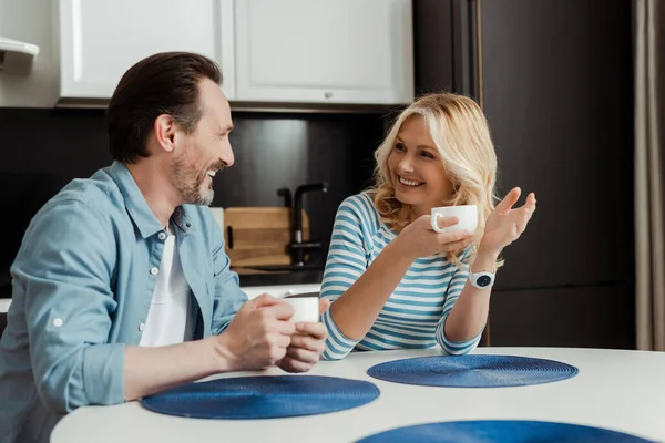 Mature Couple Smiling Each Other While Drinking Coffee Home — Stock Photo, Image