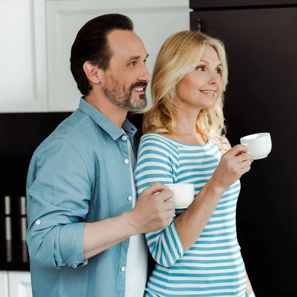 Sonriente Hombre Pie Cerca Hermosa Esposa Con Taza Café Casa — Foto de Stock