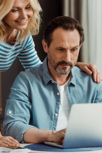 Enfoque Selectivo Mujer Madura Sonriente Abrazando Marido Usando Ordenador Portátil — Foto de Stock