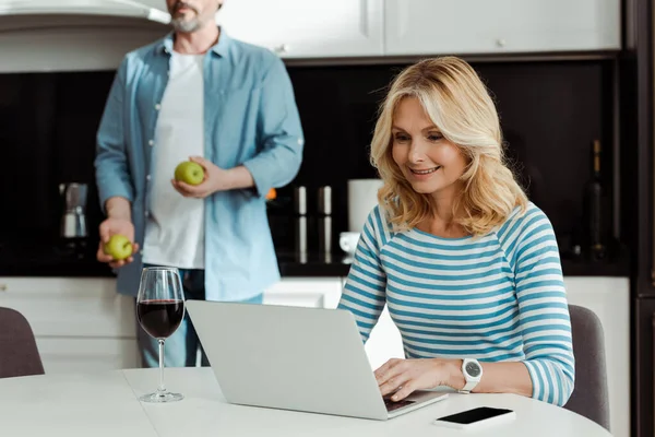 Selective Focus Smiling Woman Using Laptop Glass Wine Husband Apples — Stock Photo, Image