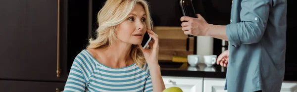 Cultivo Panorámico Mujer Hablando Teléfono Inteligente Cerca Hombre Sosteniendo Botella — Foto de Stock