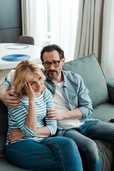Man Embracing Worried Wife Couch Home — Stock Photo, Image