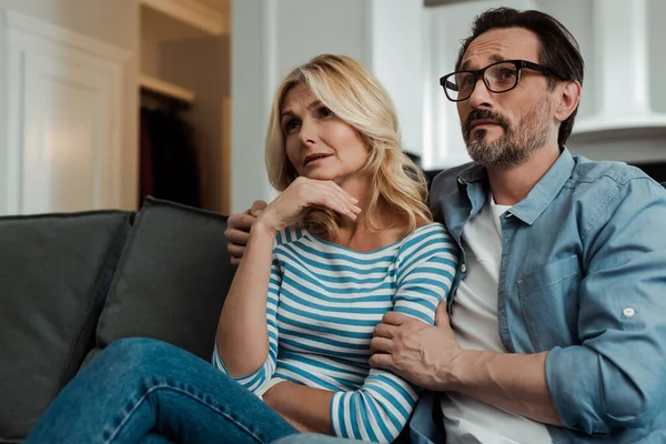 Knappe Man Omarmen Vrouw Bank Woonkamer — Stockfoto