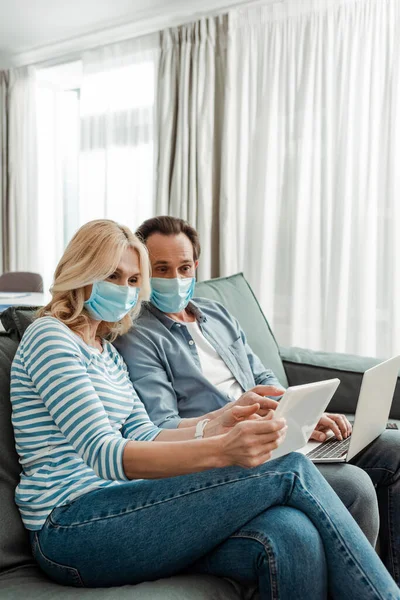 Pareja Mediana Edad Máscaras Médicas Utilizando Tableta Digital Portátil Sala — Foto de Stock