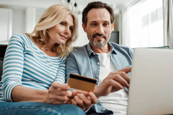 Selective Focus Smiling Man Pointing Laptop Wife Holding Credit Card — Stock Photo, Image