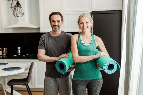 Pareja Madura Ropa Deportiva Sonriendo Cámara Mientras Sostiene Alfombras Fitness — Foto de Stock