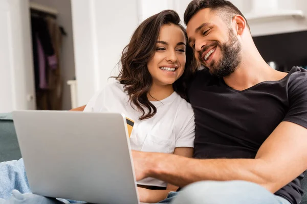 Mujer Feliz Celebración Tarjeta Crédito Cerca Novio Barbudo Portátil — Foto de Stock