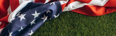 Amerikan bayrağının yatay görüntüsü. Dışarıda yeşil çimlerin üzerinde yıldızlar ve çizgiler var. İşçi bayramı konsepti. 