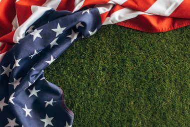 Dışarıda yeşil çimlerin üzerinde çizgili Amerikan bayrağının üst görüntüsü, İşçi Bayramı konsepti. 