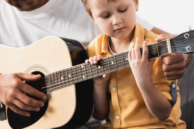 Baba 'nın özenli oğluna akustik gitar çalmayı öğrettiği görüntüler.