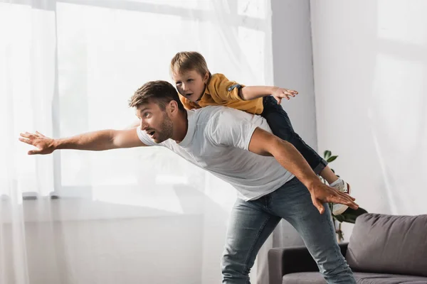 Handsome Father Piggybacking Happy Son Imitating Flying Outstretched Hands — Stock Photo, Image