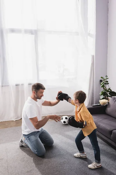 Schattig Jongen Bokshandschoenen Vechten Met Vader Staan Knieën Vloer — Stockfoto