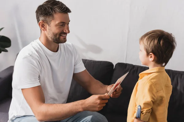 Feliz Hombre Sosteniendo Feliz Padre Día Tarjeta Cerca Lindo Hijo —  Fotos de Stock