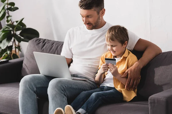 Hombre Guapo Usando Ordenador Portátil Mientras Que Hijo Sonriente Con — Foto de Stock