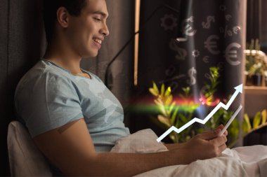 smiling mixed race man using digital tablet in bed near virtual dollar and euro signs near graph with growing rate  clipart
