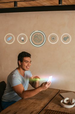 Akıllı telefon, dizüstü bilgisayar, kulaklık, parmak izi ve sanal ikonları gösteren mutlu bir melez. 