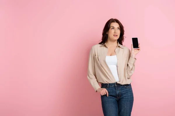 Donna Pensierosa Che Mostra Smartphone Con Schermo Bianco Sfondo Rosa — Foto Stock