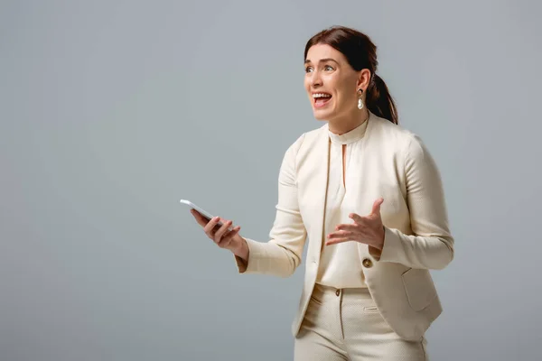 灰色に隔離されたスマートフォンを保持する怒っているビジネス女性 体の肯定的な概念 — ストック写真