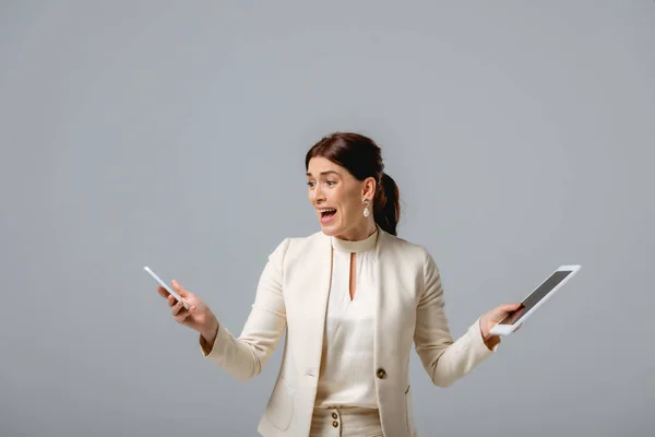 Mujer Negocios Asustada Sosteniendo Teléfono Inteligente Tableta Digital Aislado Gris — Foto de Stock