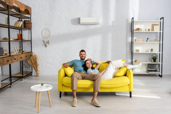 Young Couple Smiling Camera While Sitting Yellow Couch Home — Stock Photo, Image