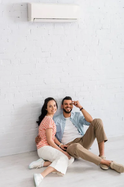 Bearded Man Embracing Girlfriend While Sitting Floor Air Conditioner Wall — Stock Photo, Image