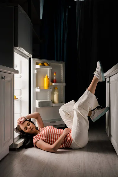 Belle Femme Couchée Sur Sol Près Réfrigérateur Ouvert Dans Cuisine — Photo