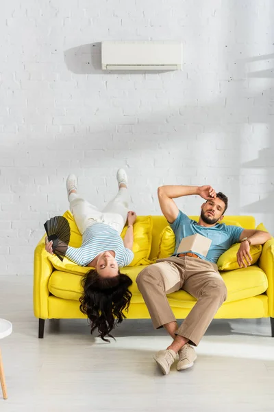 Tired Couple Book Fan Suffering Heat Sofa Living Room — Stock Photo, Image